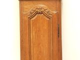 a tall wooden grandfather clock on display against a white wall