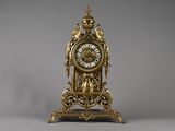 une horloge en or posée sur un socle