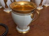 a lot of white and gold coffee cups on a table