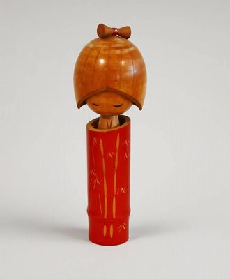 une petite figurine en bois surmontée d'une pomme