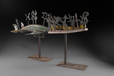 sculpture représentant un poisson posée sur un socle, avec une pancarte sur le côté