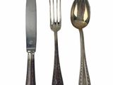 three forks and a knife sitting next to each other
