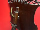an antique wooden coat rack with a coat hook on it