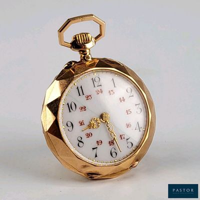 une montre de poche en or posée sur une surface blanche