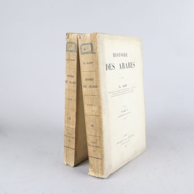 un vieux livre posé sur une table à côté d'un mur blanc