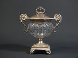 a silver vase with a lid on a stand