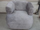 a grey chair that is sitting in a garage