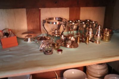 a table with a lot of silver dishes and cups on it