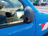 a dog sitting in the driver ' s seat of a blue truck