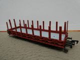 un wagon de petit train orné d'une clôture rouge sur le côté