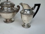 a silver tea pot and a silver coffee pot on a table