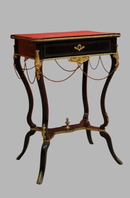 a black table with a red top and gold trimmings