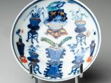 blue and white plate with a design of animals and plants