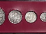 six silver coins in a red case on a white surface