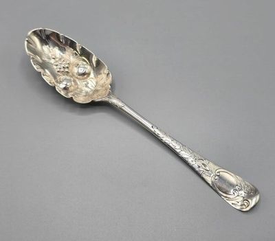 une cuillère en argent dont le manche est orné d'un motif floral