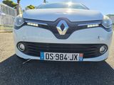 the front end of a white car with a number plate on it