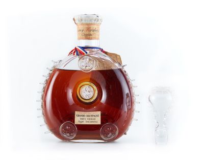 une image représentant une bouteille de brandy avec un verre posé devant