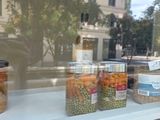 several jars of food sit on a shelf in front of a window