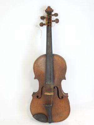 un vieux violon posé sur une surface blanche, près d'un mur blanc