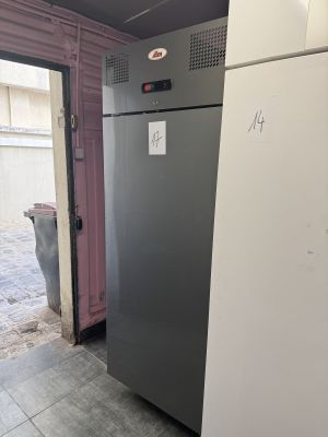un réfrigérateur qui se trouve dans un garage dont la porte est ouverte
