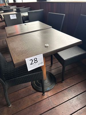 des tables et des chaises sur une terrasse en bois, avec une étiquette de prix posée sur la table