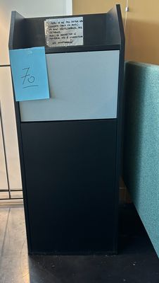 un réfrigérateur noir orné d'un autocollant bleu, dans un coin de la pièce
