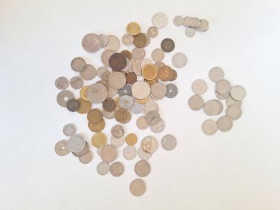 un tas de pièces de monnaie posées sur une table, sur fond blanc