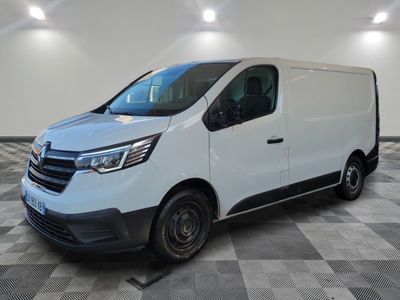 Une camionnette blanche est garée dans une pièce dont le sol est en damier.