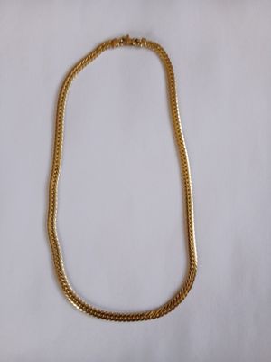 un collier en or sur fond blanc
