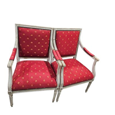 a pair of red upholstered chairs with gold dots on them