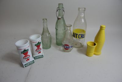 Des bouteilles et des tasses sont posées les unes à côté des autres sur une table.