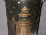 a metal bucket with a painting of a pagoda on it