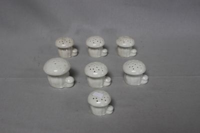 a lot of small white ceramic mushrooms on the table