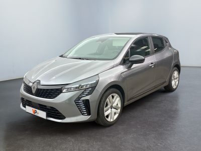 Une voiture argentée est garée dans une pièce au sol noir.