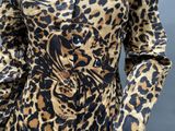 a close up of a woman wearing a leopard print dress