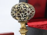 a small gold ball on a stand next to a red box