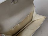 someone is holding a white purse that is open on a white table