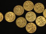 a close up of a bunch of gold coins on a black surface