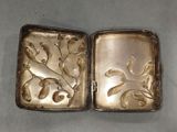 two antique silver cigarette cases with flowers and leaves on them