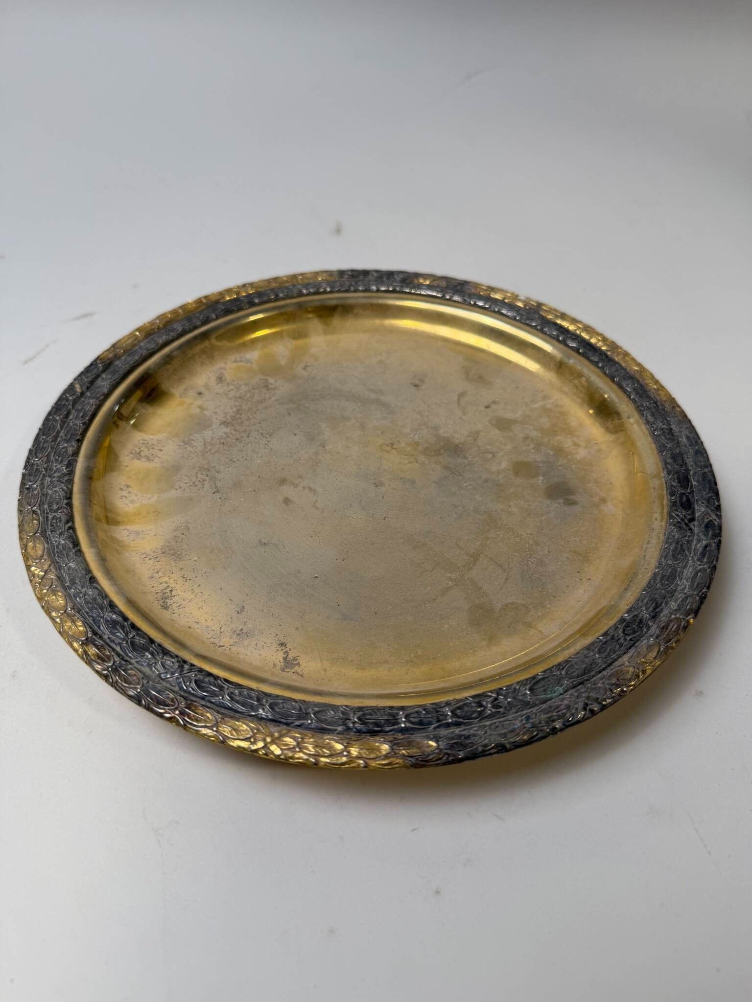 Plat en métal tétrapode de style Empire, la lèvre cernée de 2 couronnes de laurier ceintes de rubans Description : Pi...