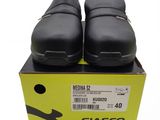 the black shoes are in a box on a white surface