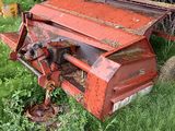 un vieux matériel agricole rouillé, abandonné dans l'herbe