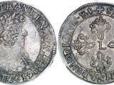 a close up of two silver coins on a white surface