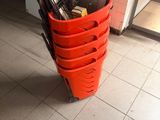 many umbrellas in a red bucket on the floor