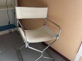 a white chair in the corner of a room with a lamp