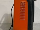an orange and black suitcase sitting on top of a cement floor