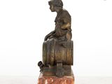 statue of a woman sitting on a barrel of wine on a marble base