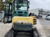 a picture of a yellow and green tractor parked in a parking lot