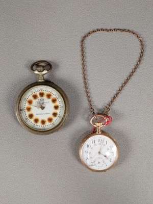 deux types différents de montres de poche exposées sur une table