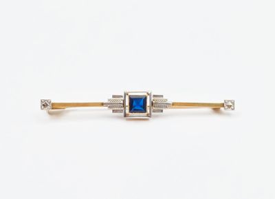 un gros plan sur une broche en forme de losange bleue et blanche